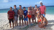 A group of people posing for a picture on the beach.