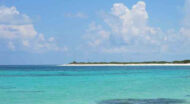 A beach with clear blue water and white sand.