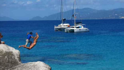 A man jumps off a rock into the water.