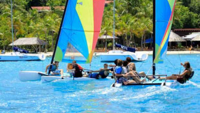 A group of people on sailboats in the ocean.