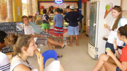 A group of people sitting in a room eating ice cream.