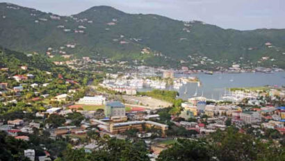 A view of a town with a boat in the water.