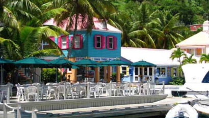 A boat docked in front of a colorful house.