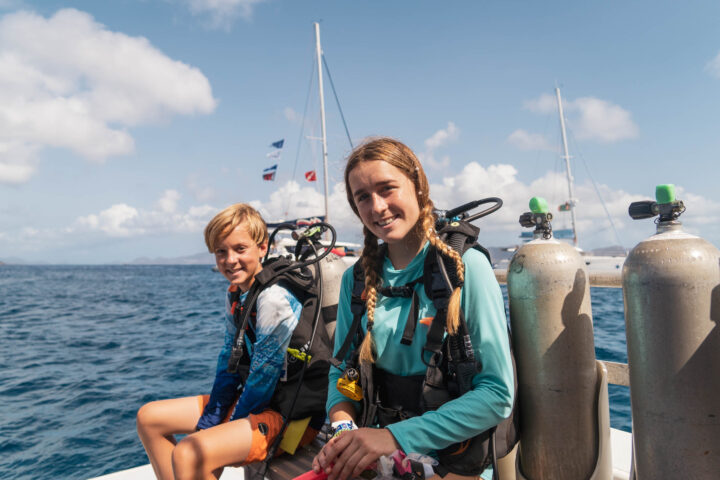 Campers in dive gear on a boat.