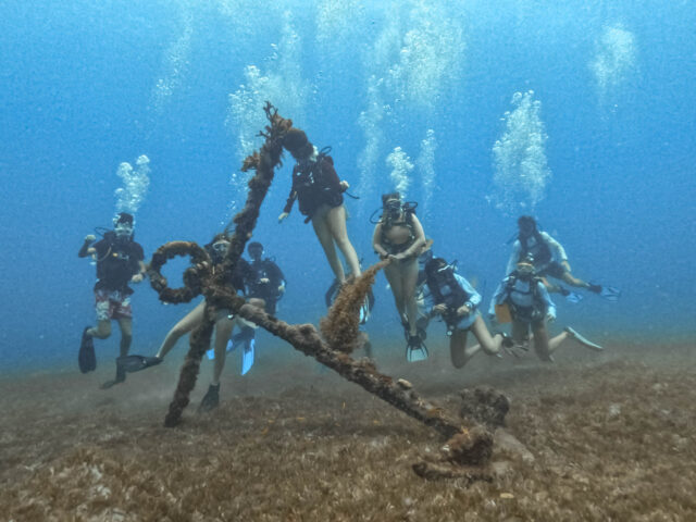 Campers diving near an old anchor.