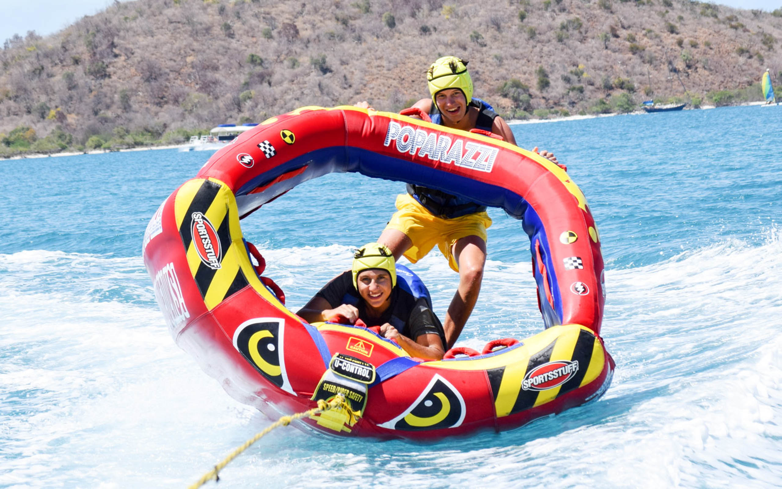 Two people riding a water raft in the ocean.