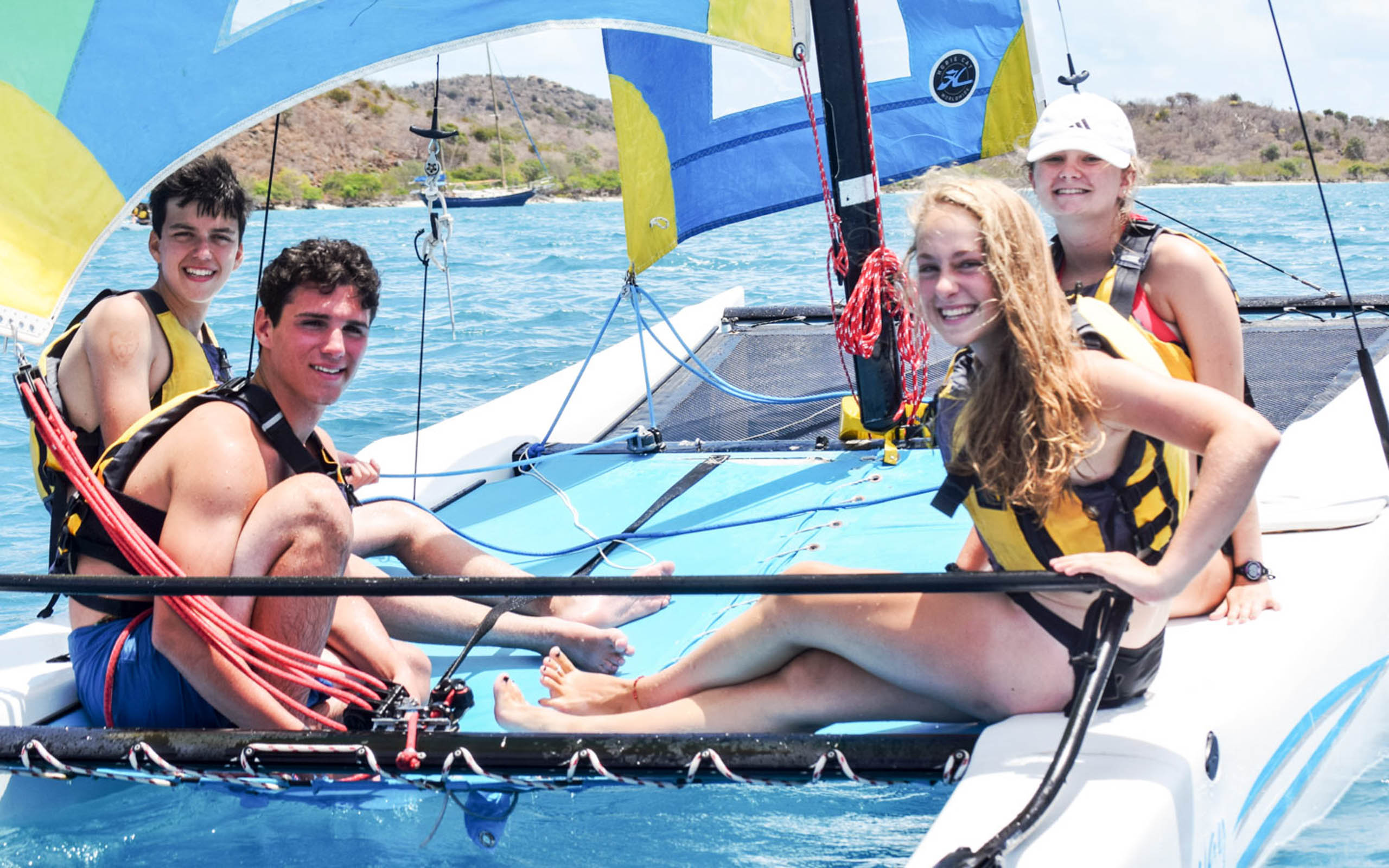 A group of people sitting on a sailboat in the ocean.