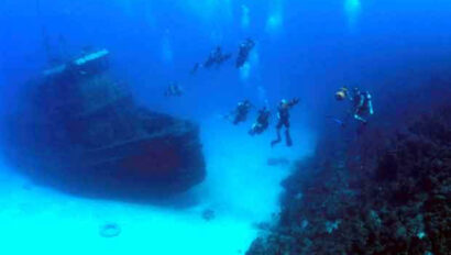 Scuba divers swimming near a ship.