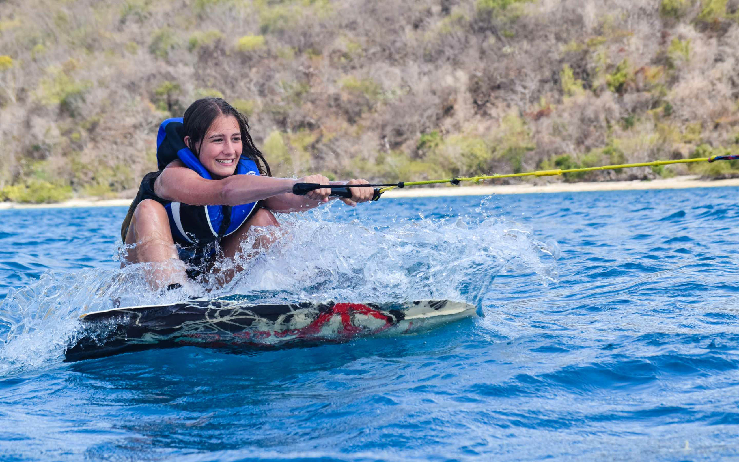 A woman is riding a wake board in the water.