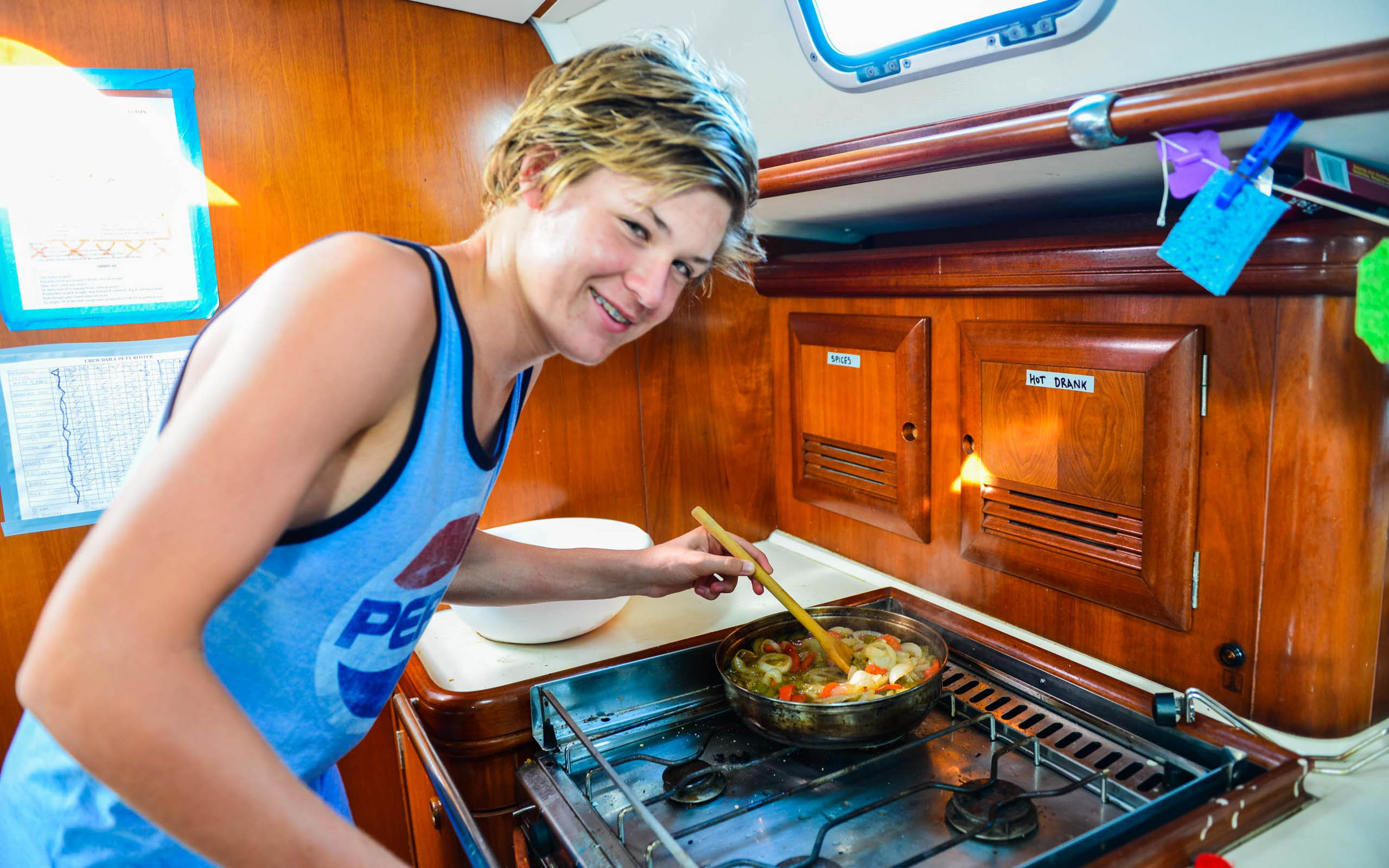 Camper cooking in a kitchen on a sailboat.