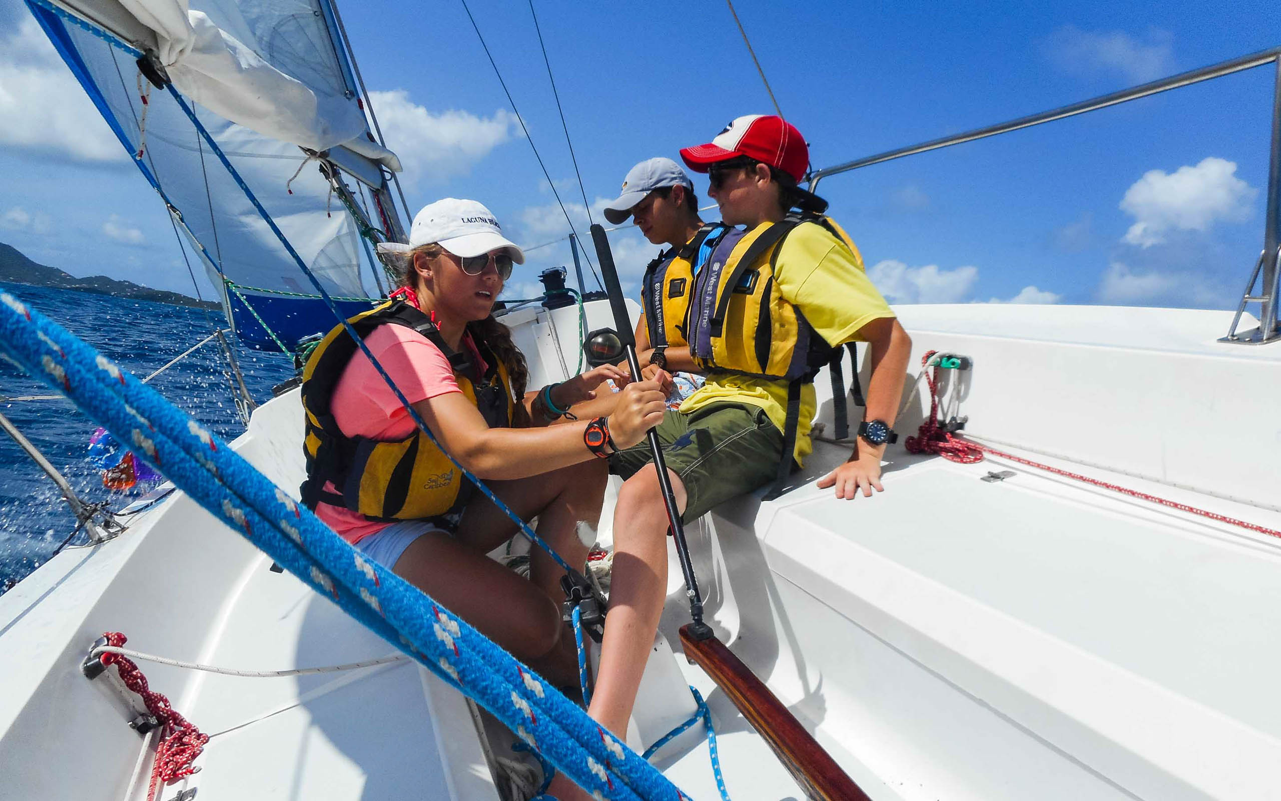 A group of people on a sailboat in the ocean.