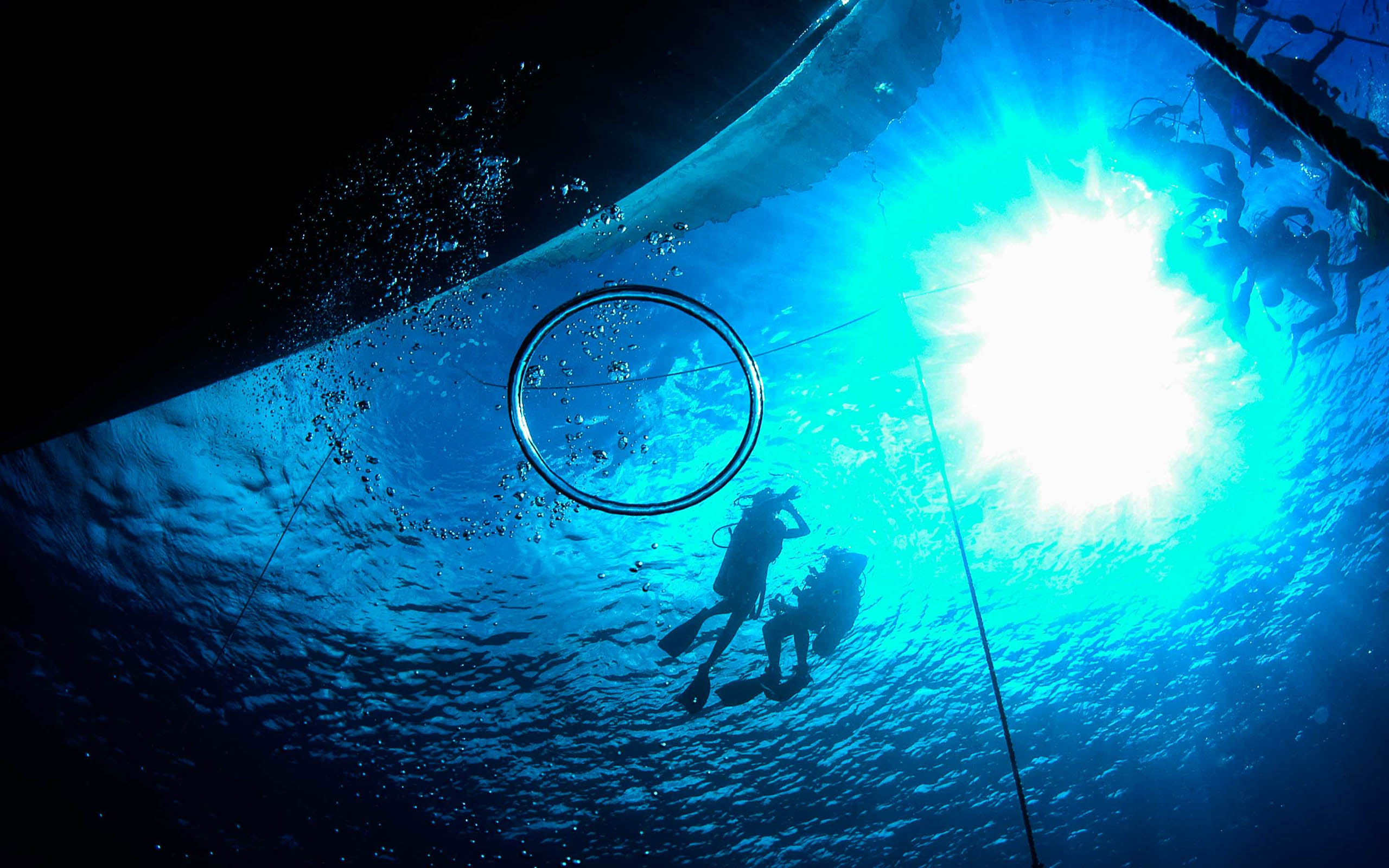 A group of people are swimming in the water under a blue sky.