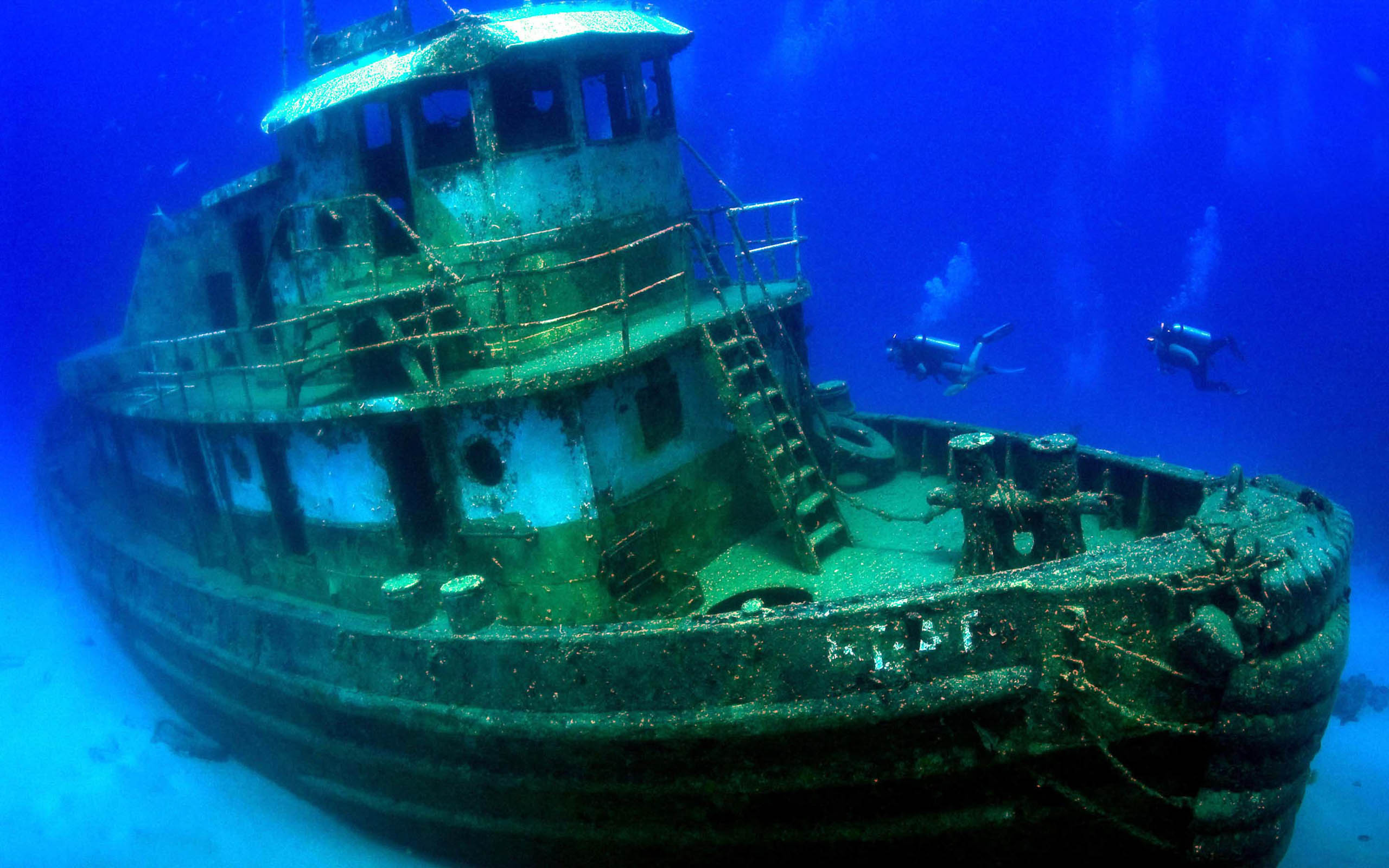 An old ship is sunk in the ocean.