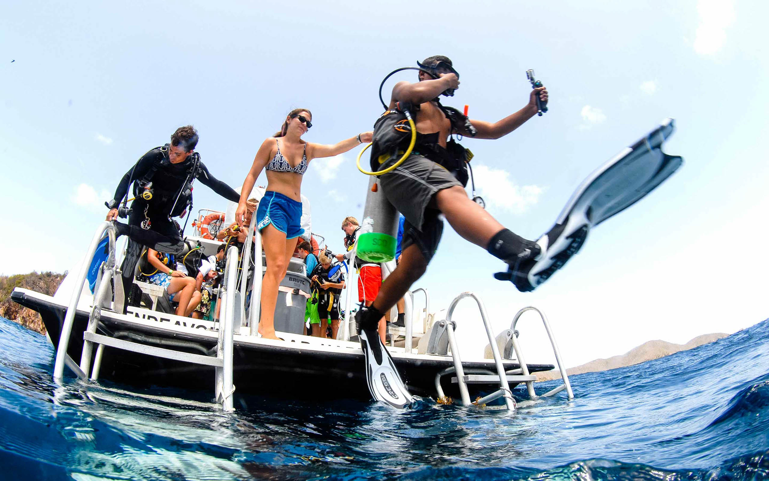 A group of people scuba diving off a boat.