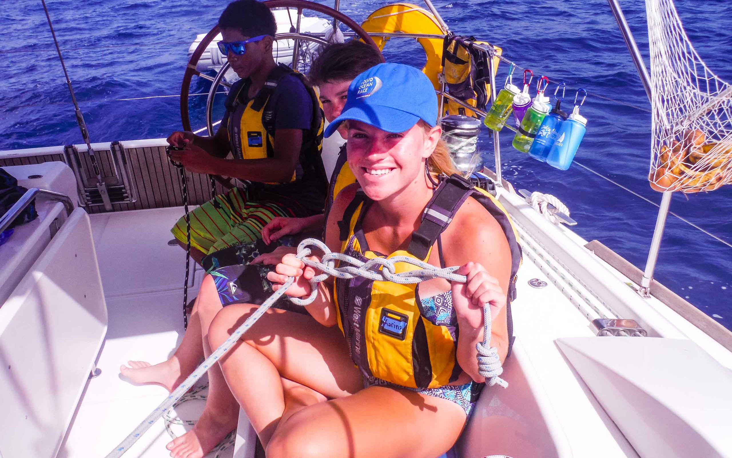 A group of people on a sailboat in the ocean.