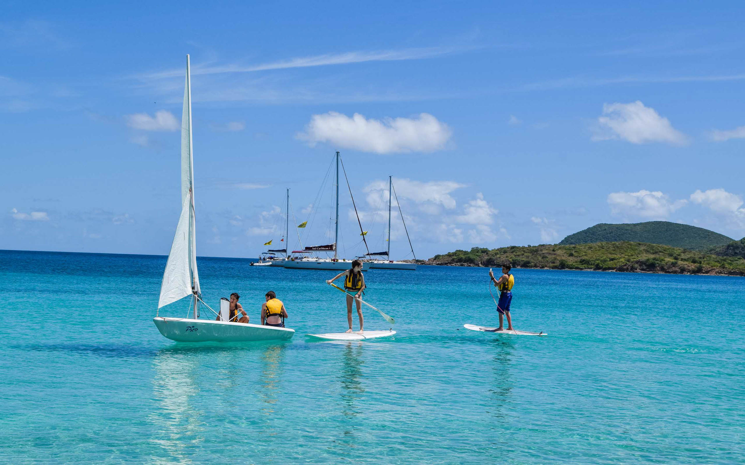 A group of people on sailboats in the water.