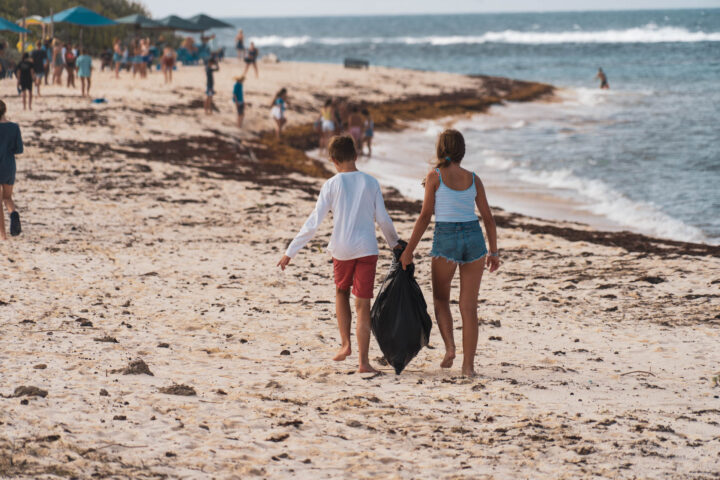 A boy and girl holding hands on a beach.