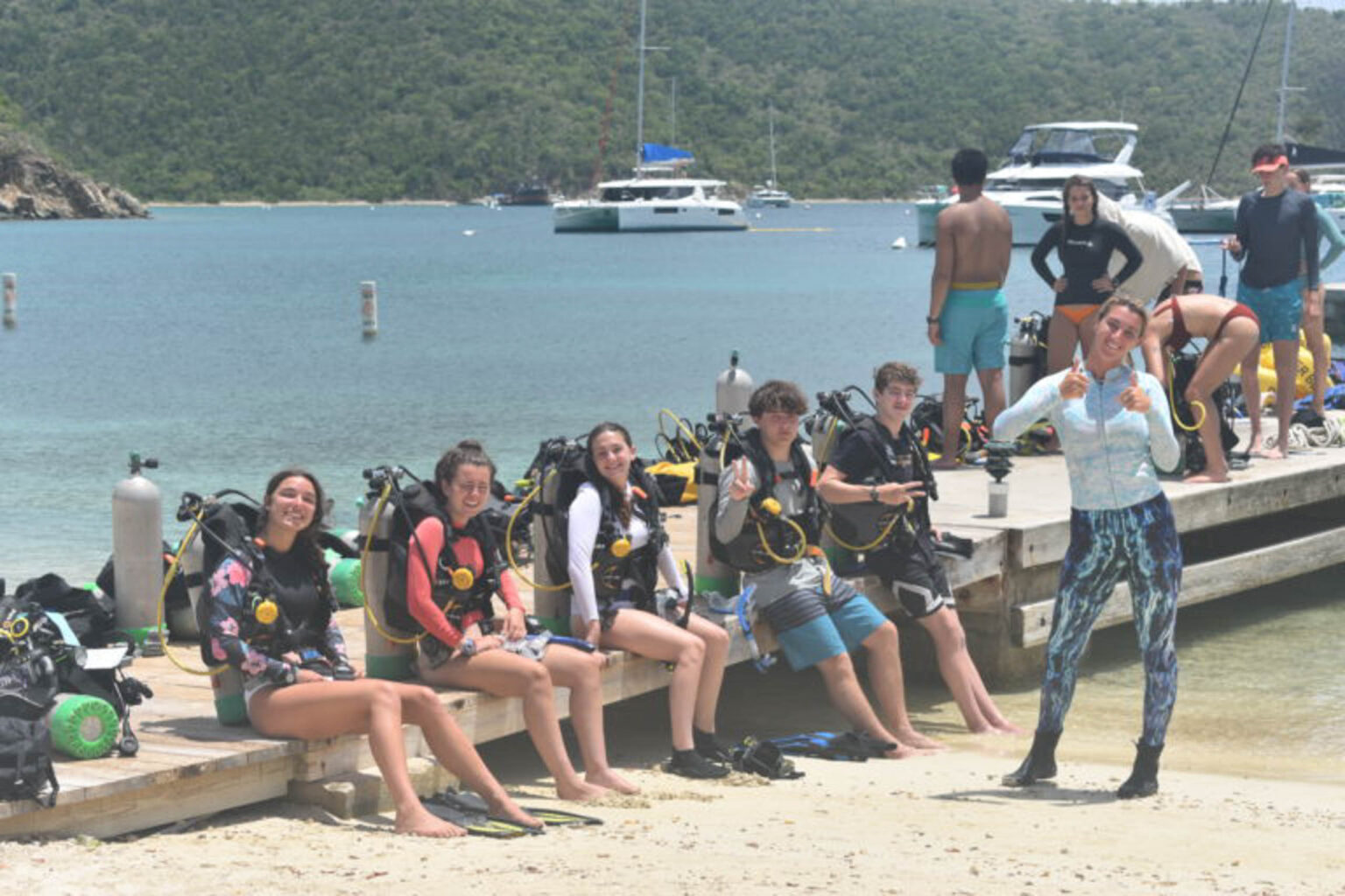 A group of people sitting on a dock.
