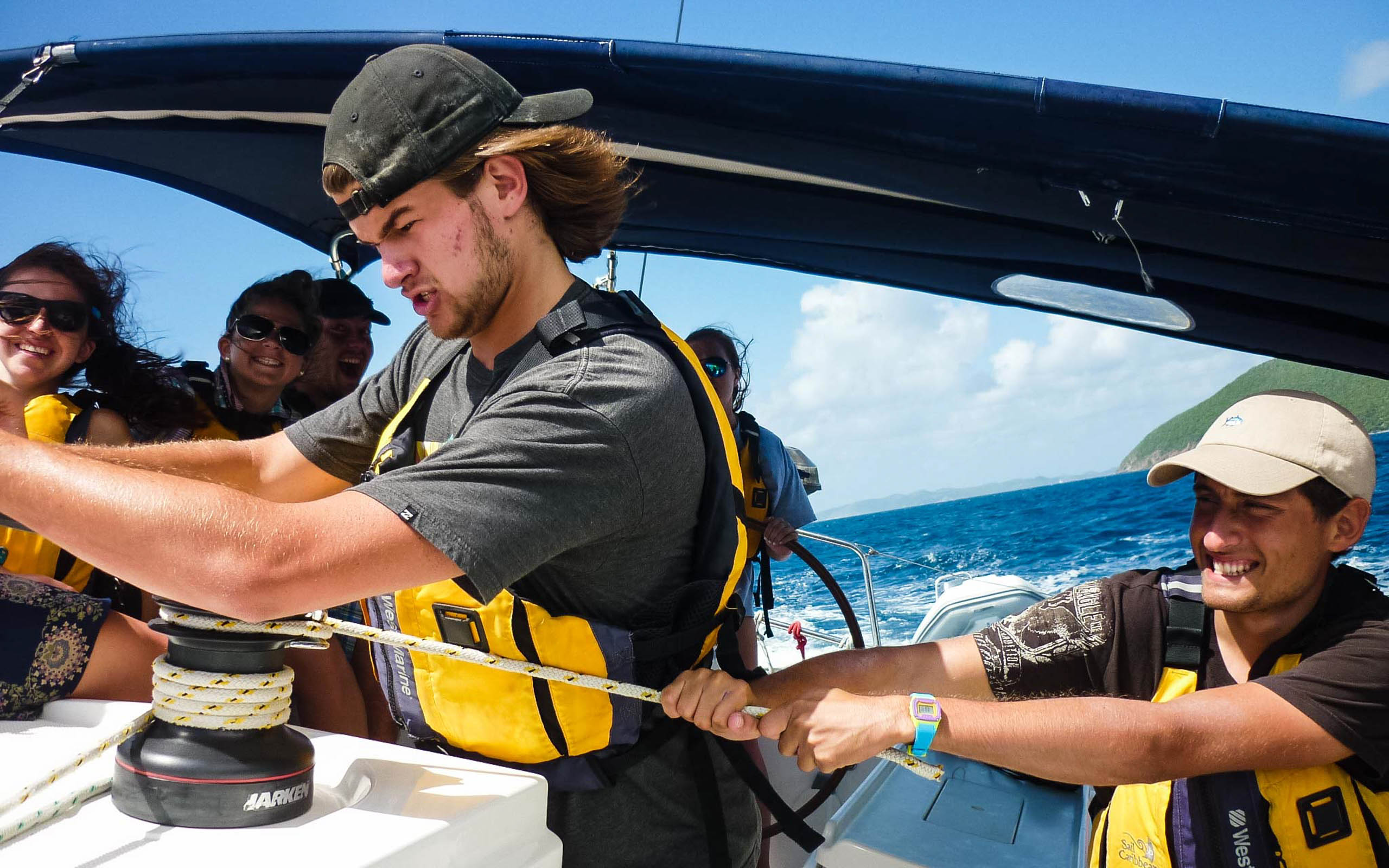 A group of people working on a sailboat.