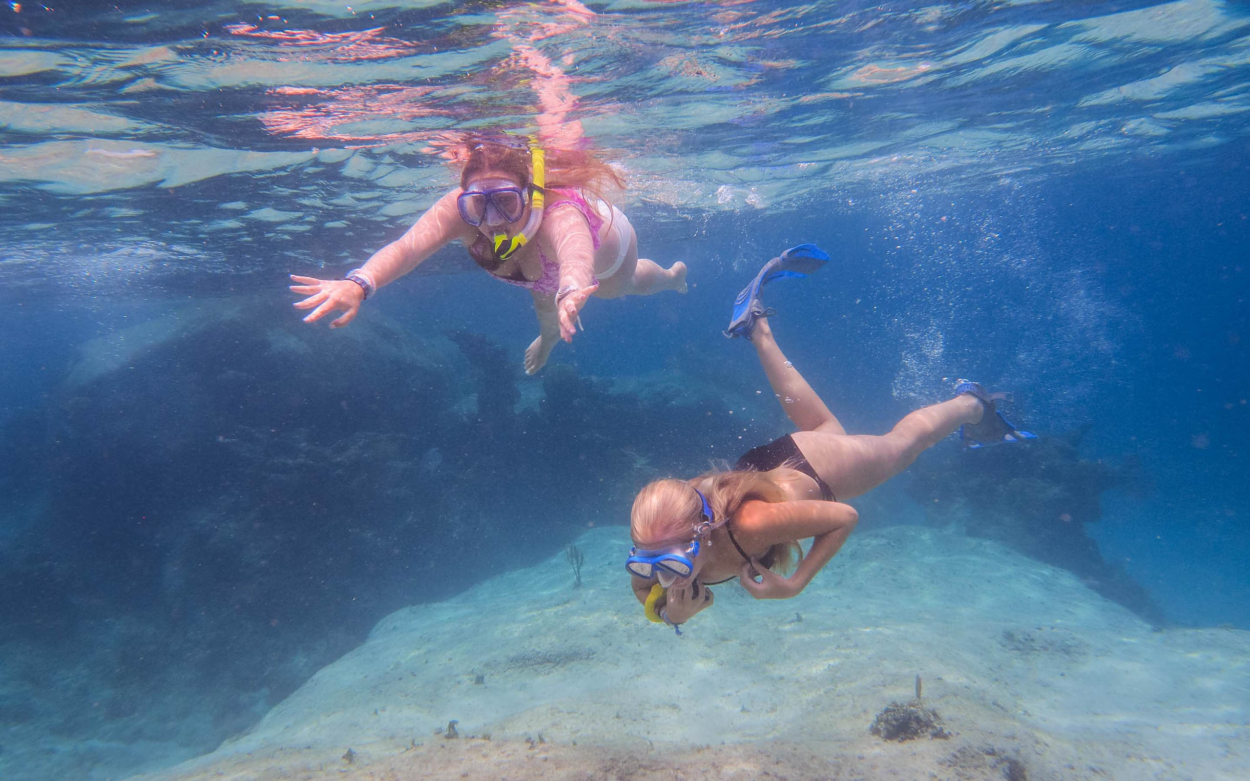 Two people snorkling in the water.
