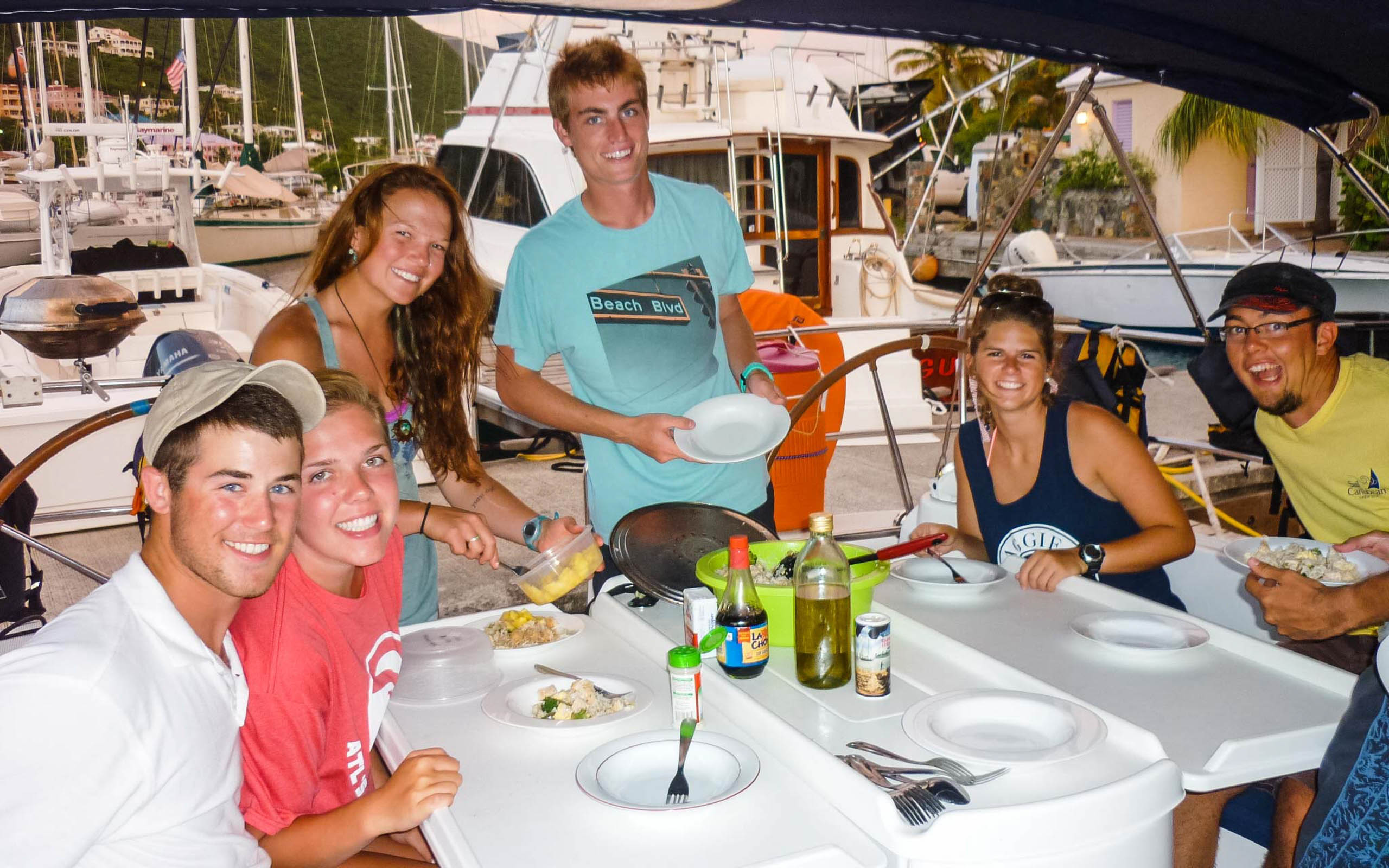 A group of people sitting at a table on a boat.