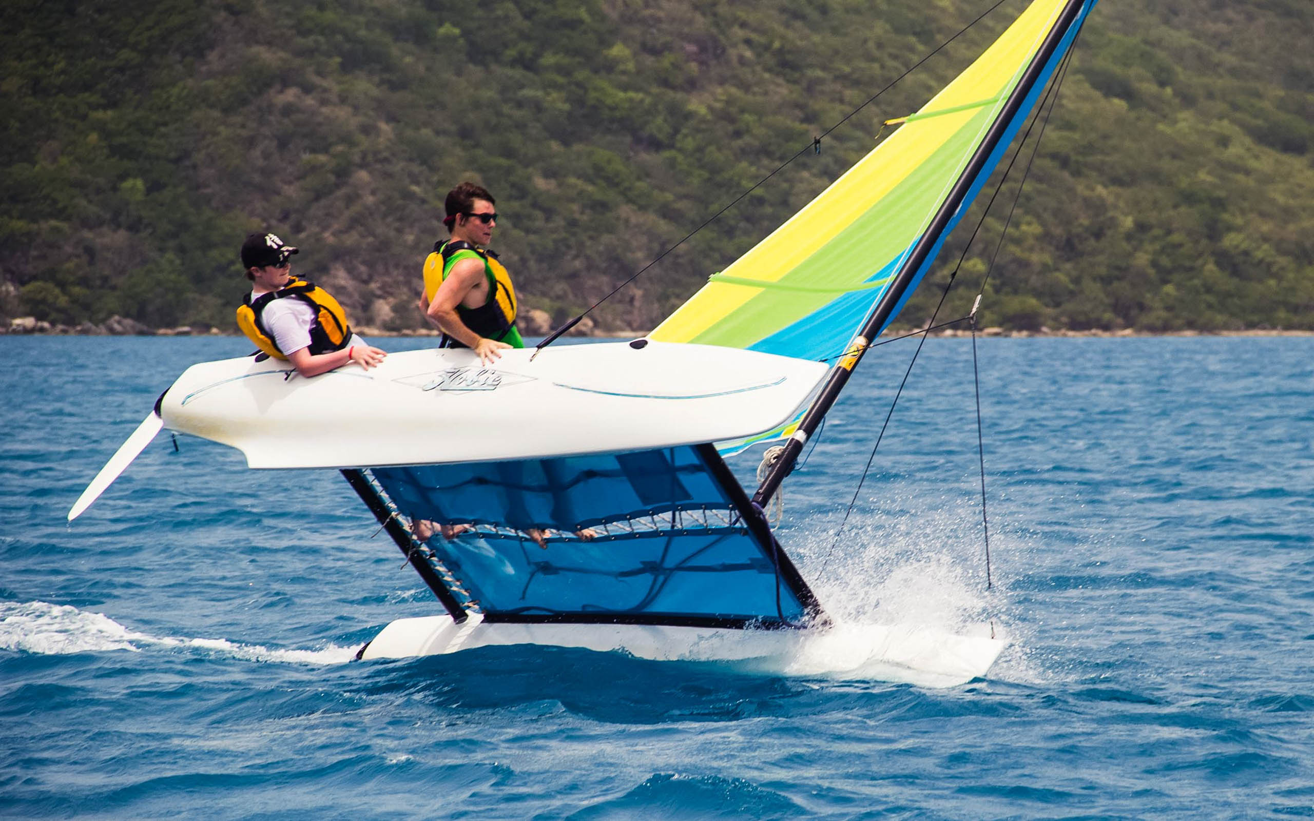 Two people on a sailboat in the ocean.