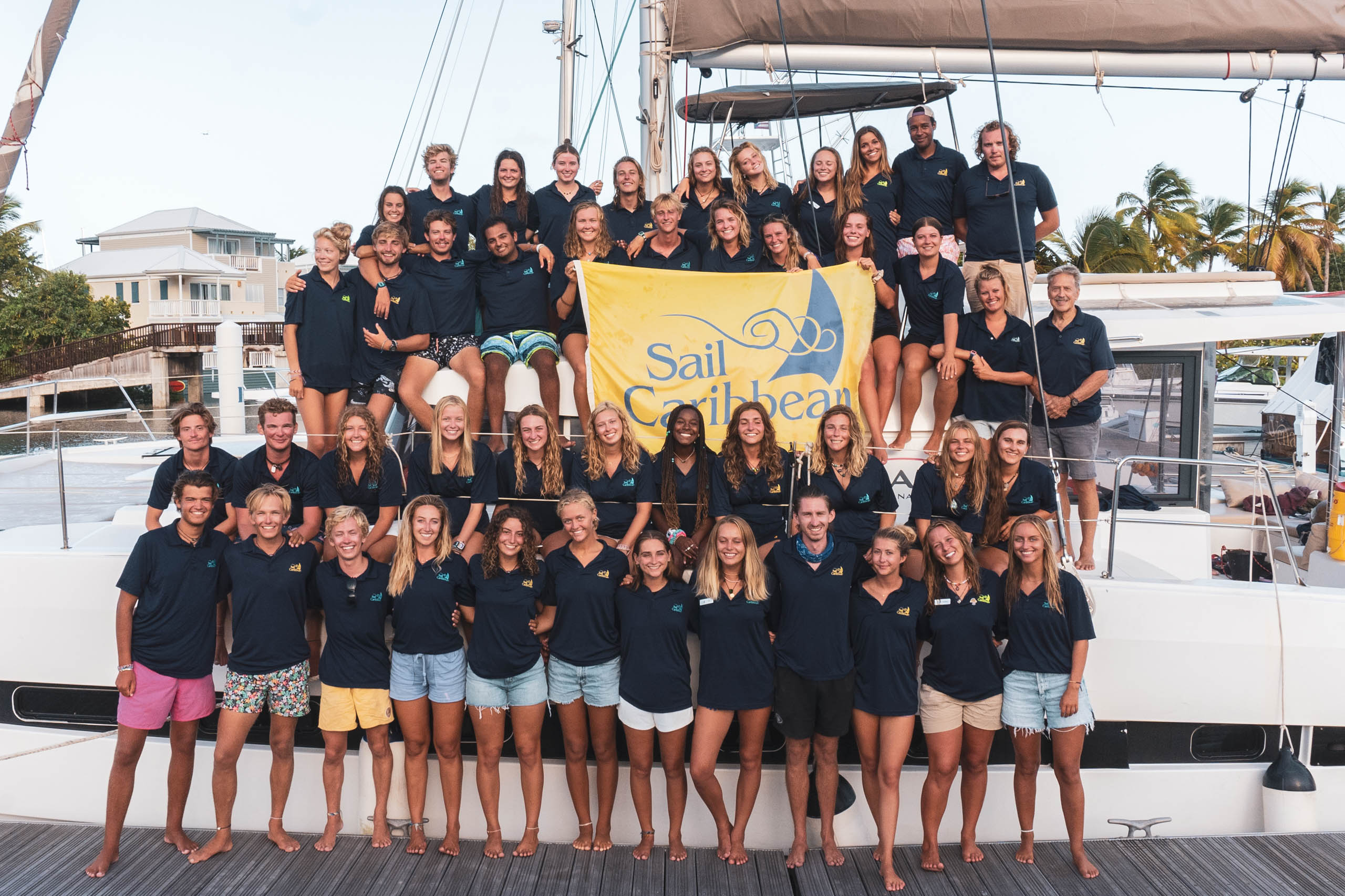 A group of Sail Caribbean staff members posing for a photo on a sailboat.