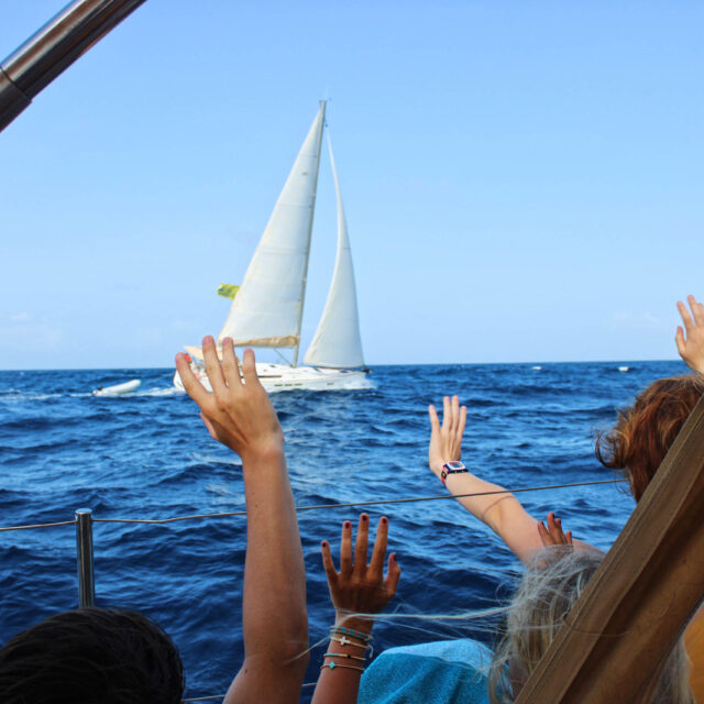 Campers waving to another Sail Caribbean boat.