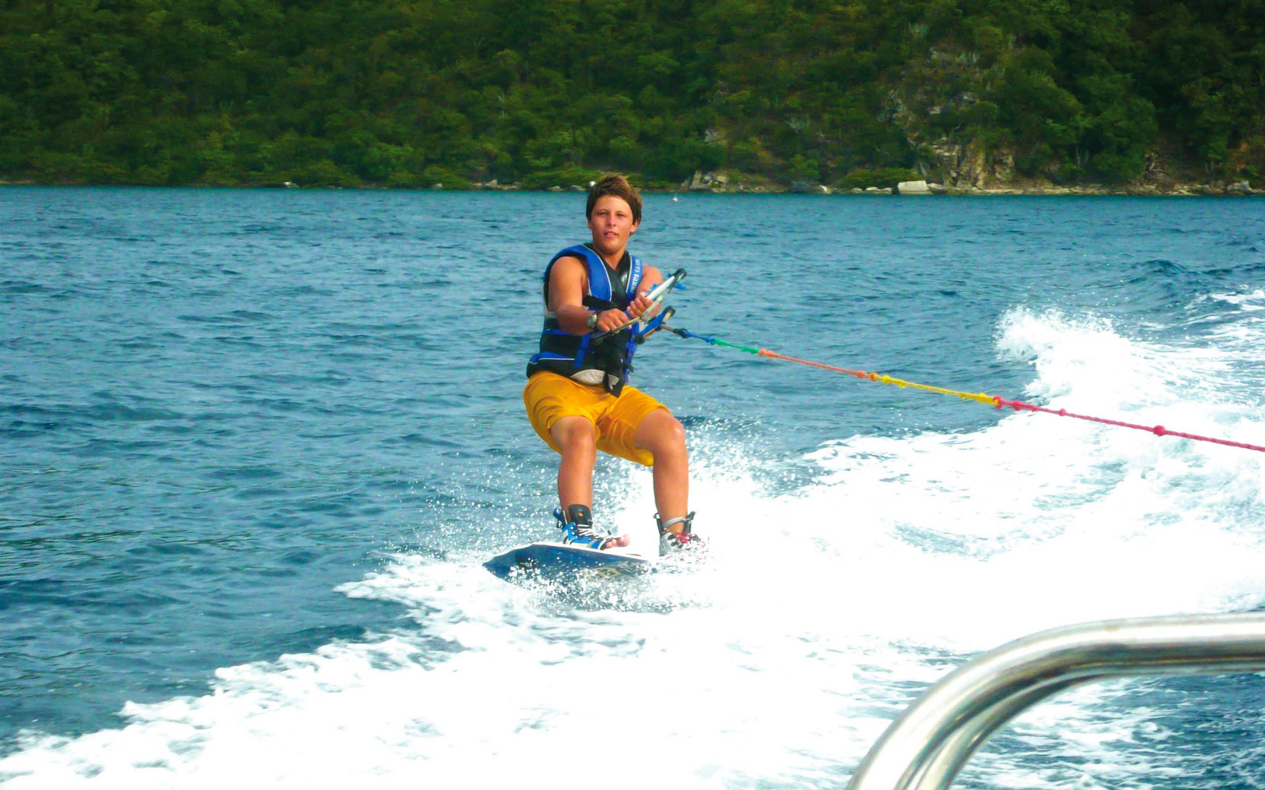 A man is water skiing on a boat.