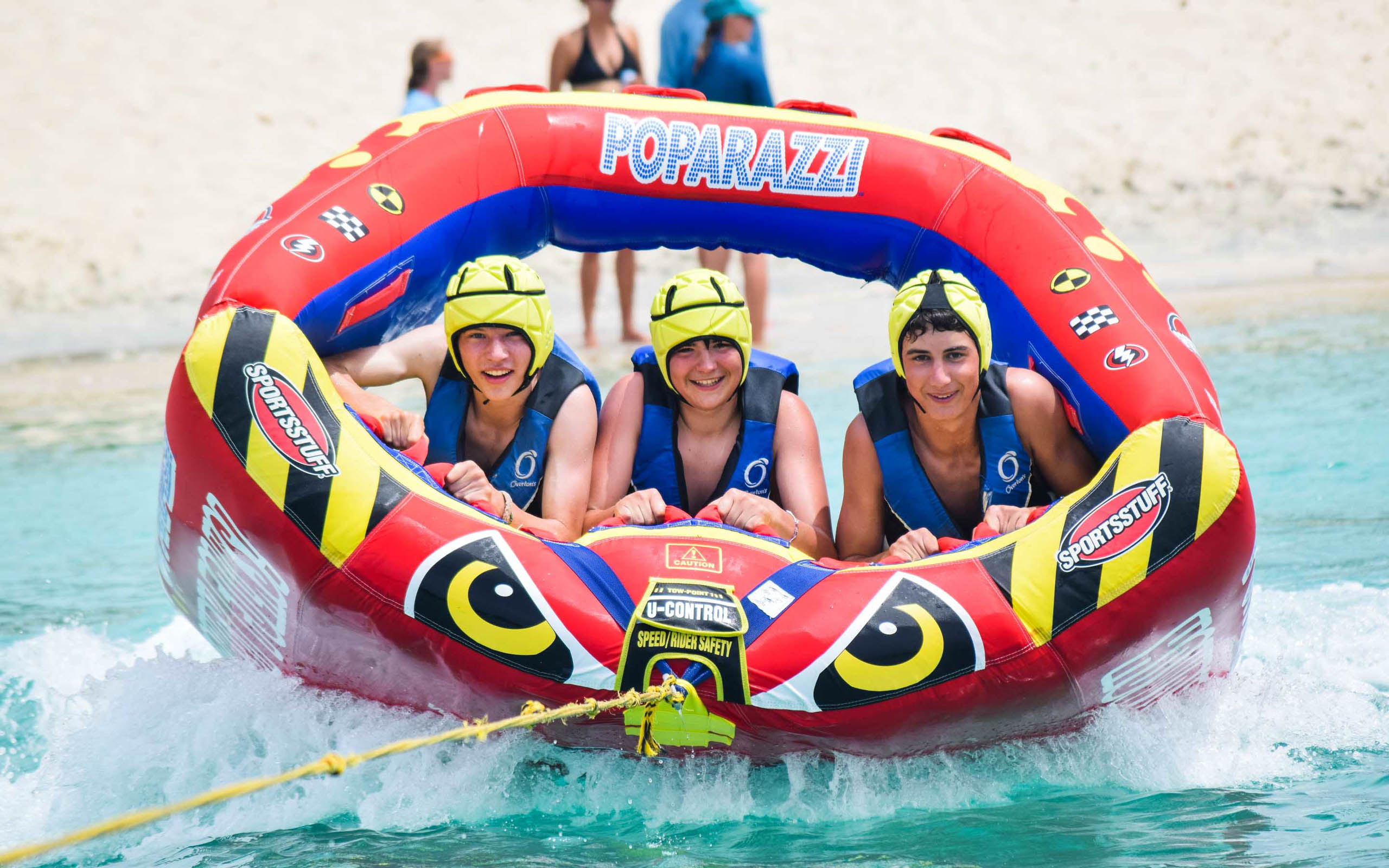A group of people riding in an inflatable raft on the water.