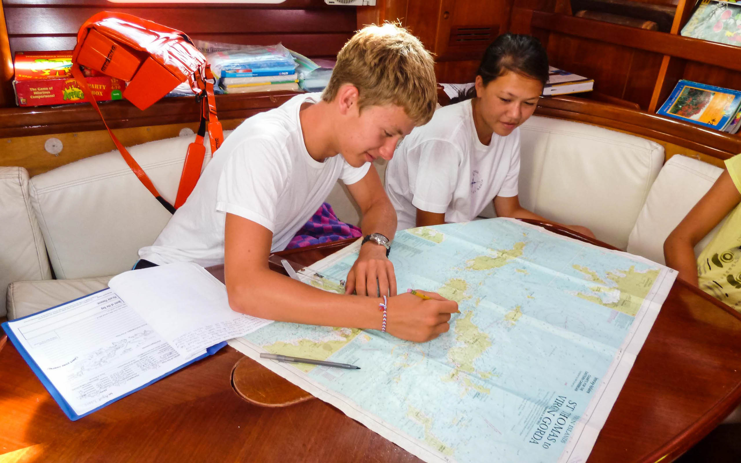 A group of people looking at a map on a boat.