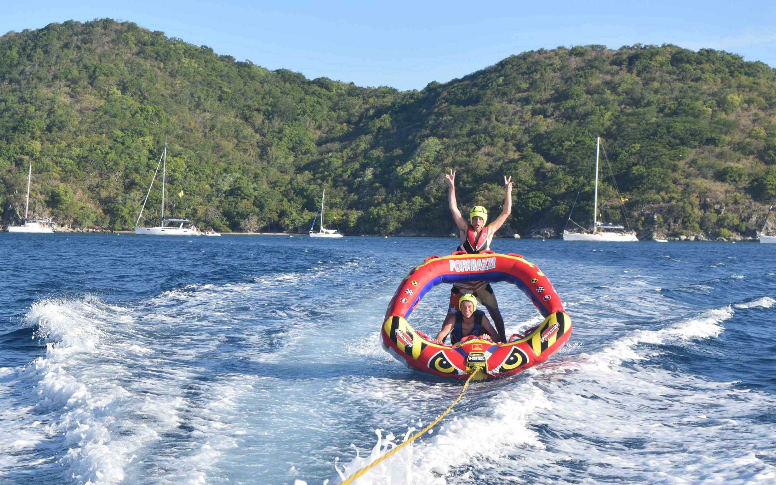 Two people riding an inflatable boat in the ocean.