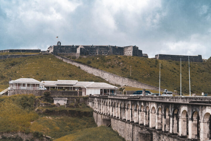 A bridge over a hill with a castle in the background.