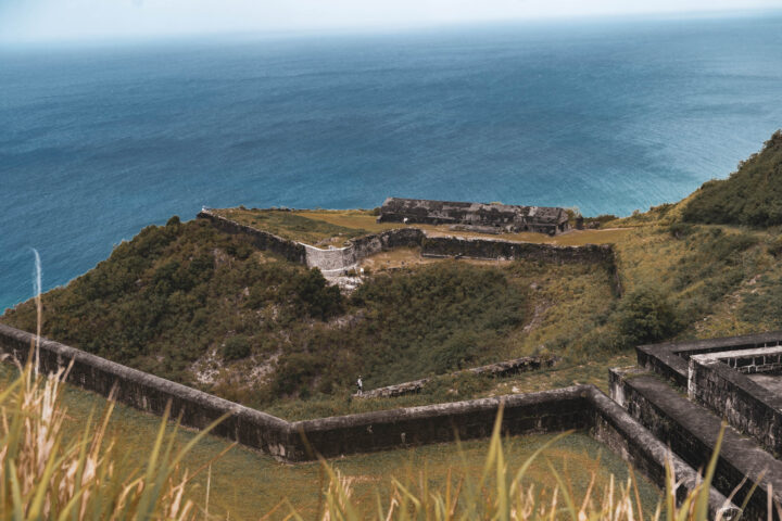 A fort on a hill overlooking the ocean.
