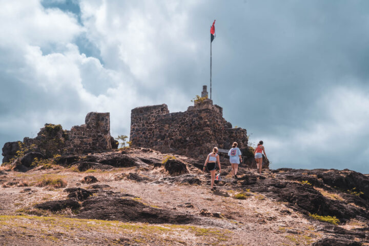 A group of people standing on top of a rocky hill.
