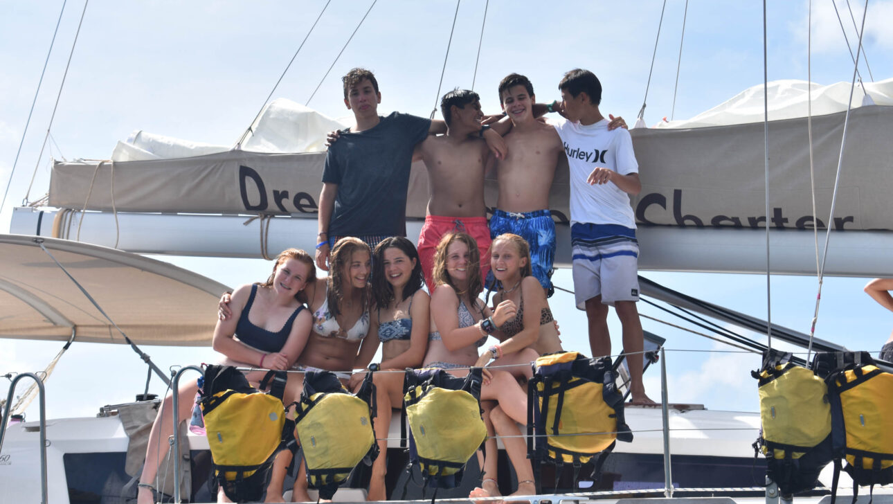 Campers posing for a photo on a sailboat.