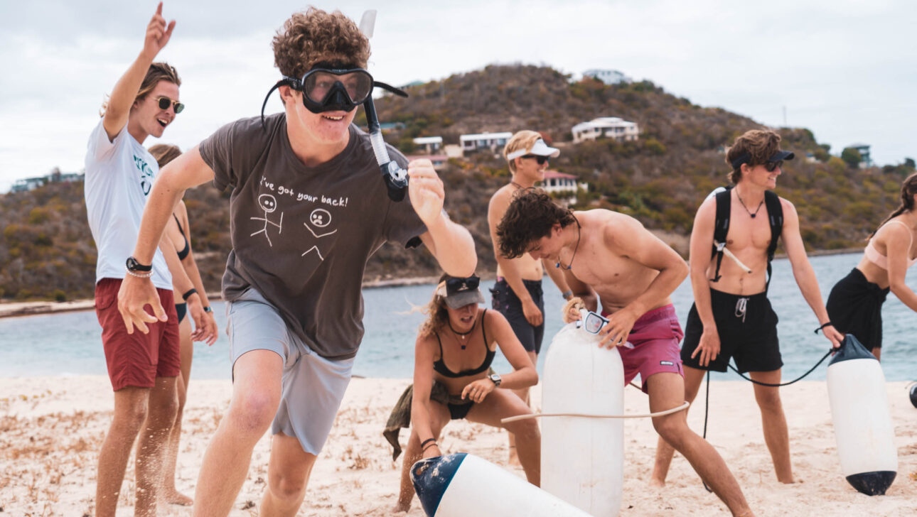 A group of people playing a game on the beach.