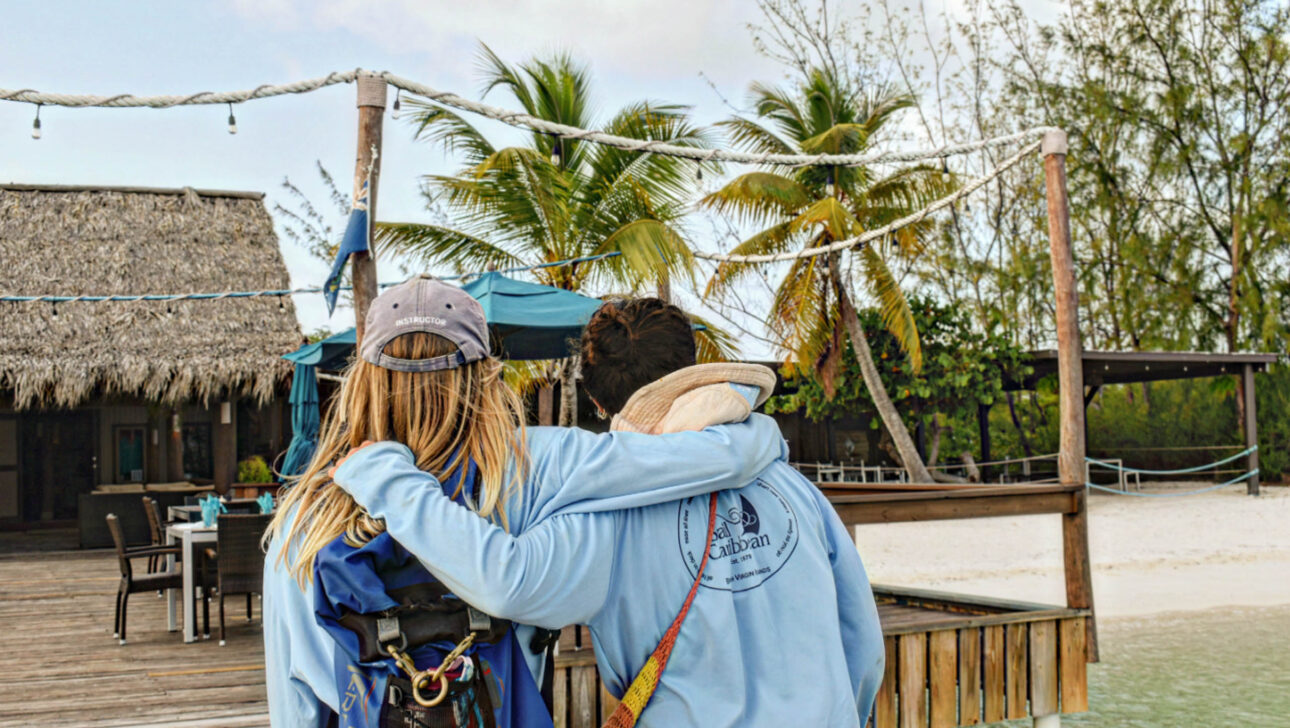 A couple of people hugging on a dock.