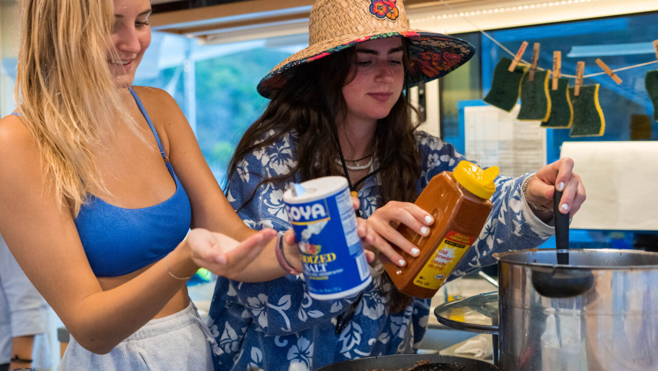 Two women preparing food in a kitchen.