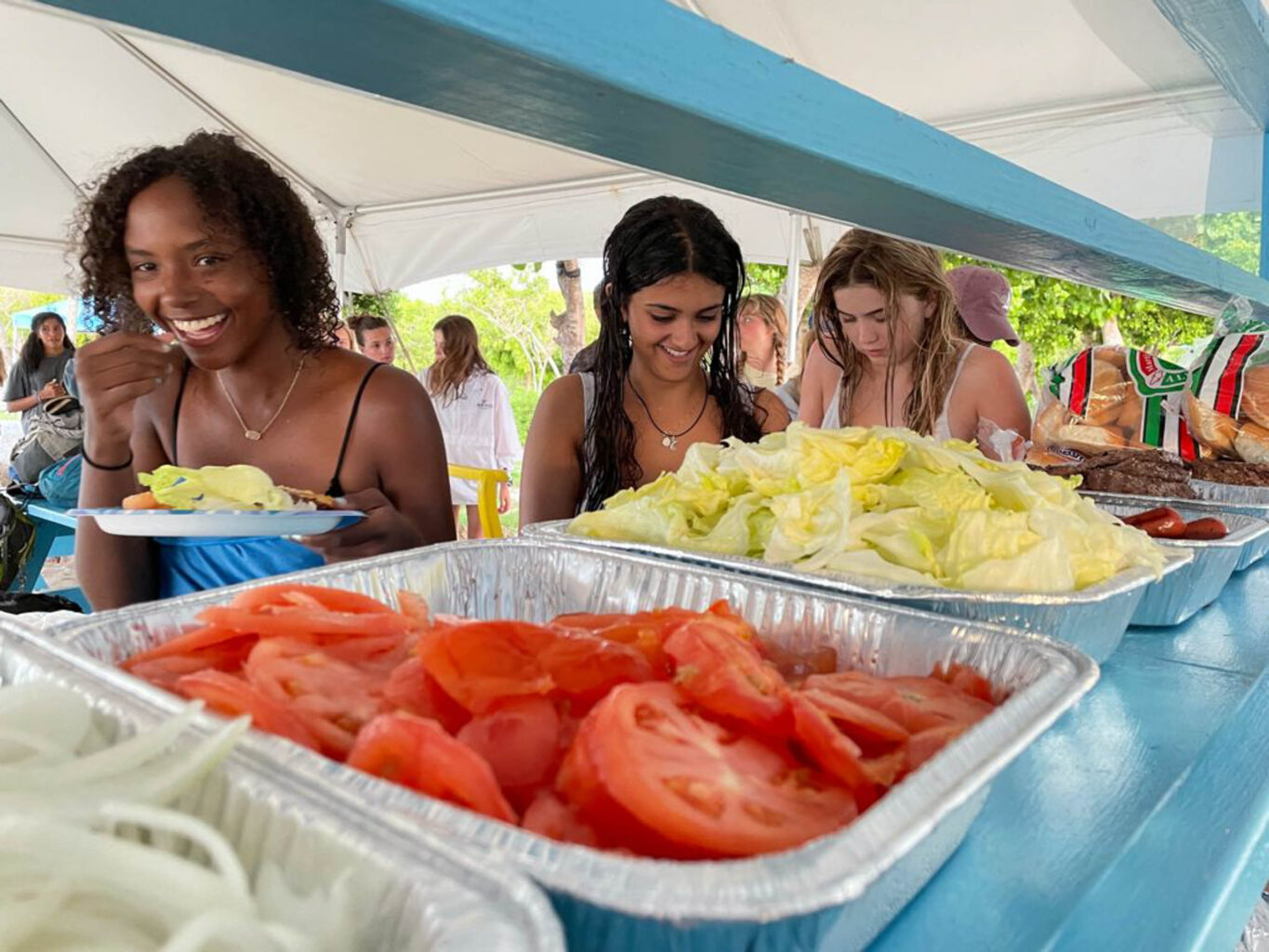 Campers eating food at a buffet.