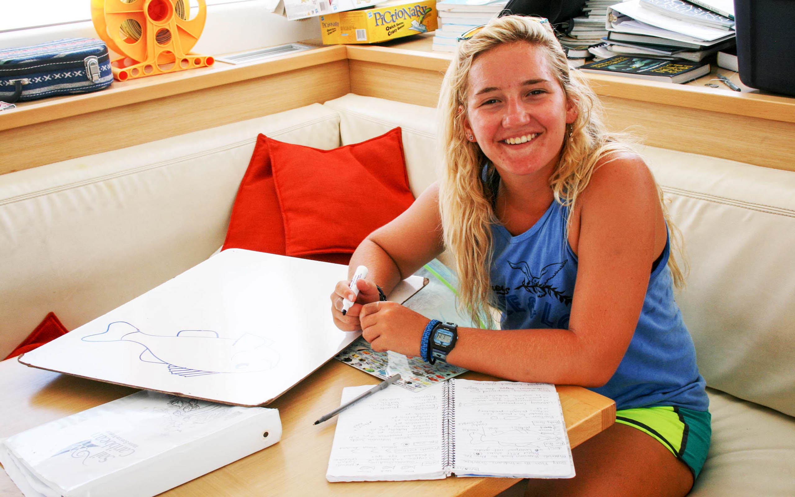 A woman sitting at a table with a notebook.