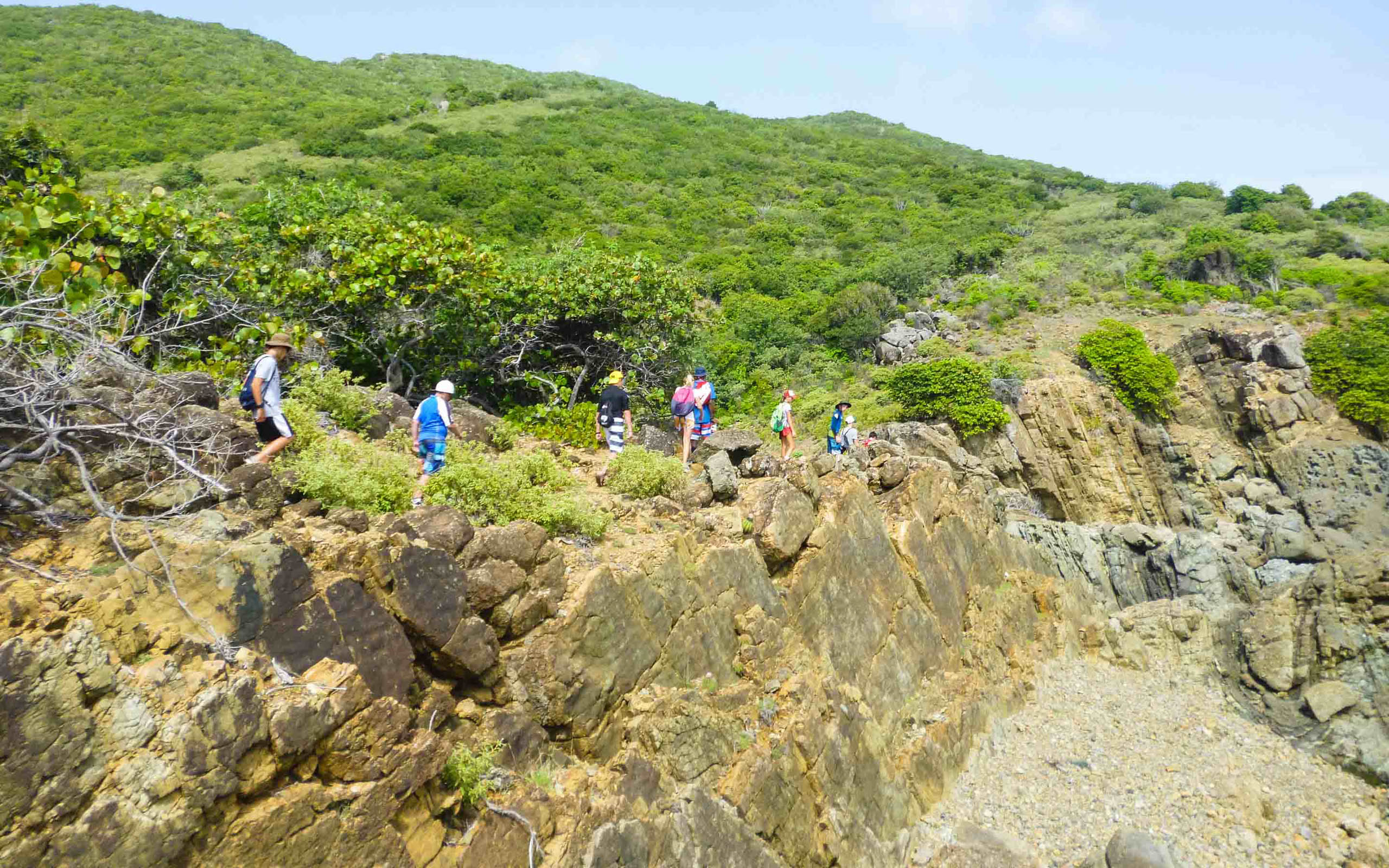 A group of people walking on a rocky cliff.