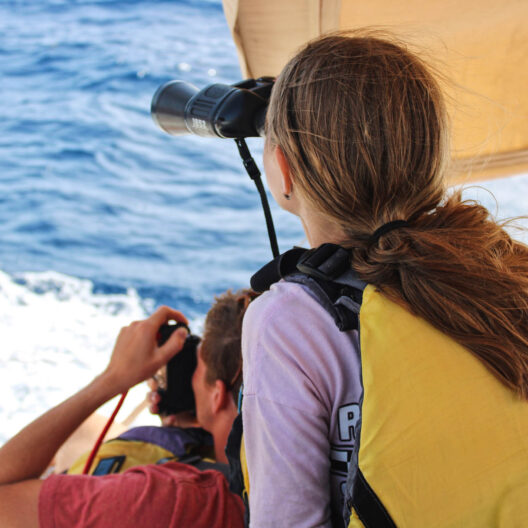 Campers using binoculars on the boat.
