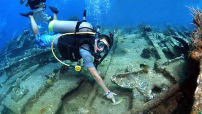 A man scuba diving on the wreck of a ship.