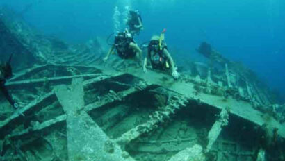A group of scuba divers on the wreck of a ship.