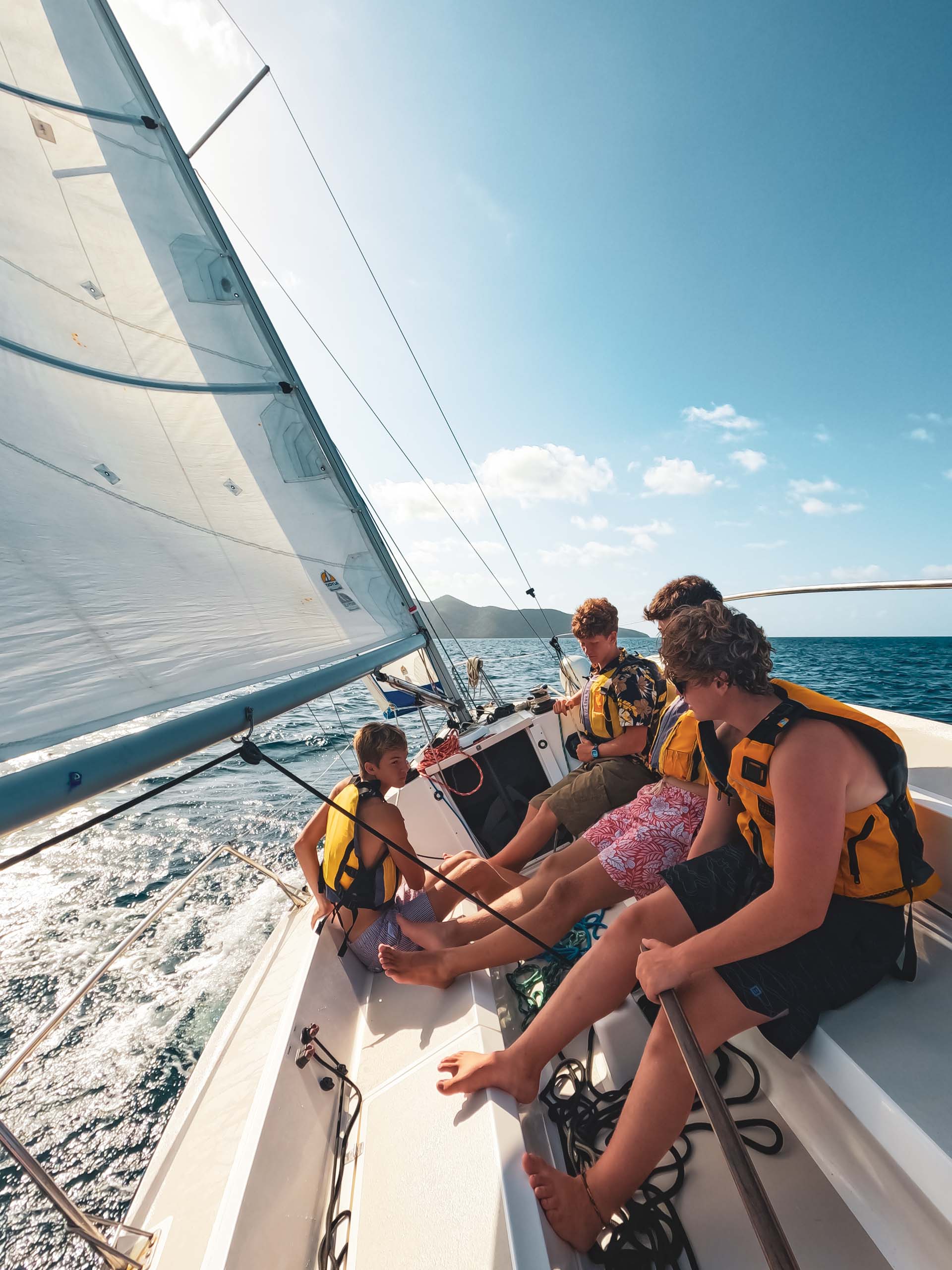 A group of people on a sailboat in the ocean.