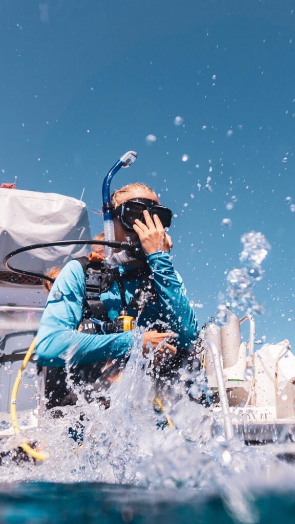 A scuba diver wearing a mask and goggles in the water.