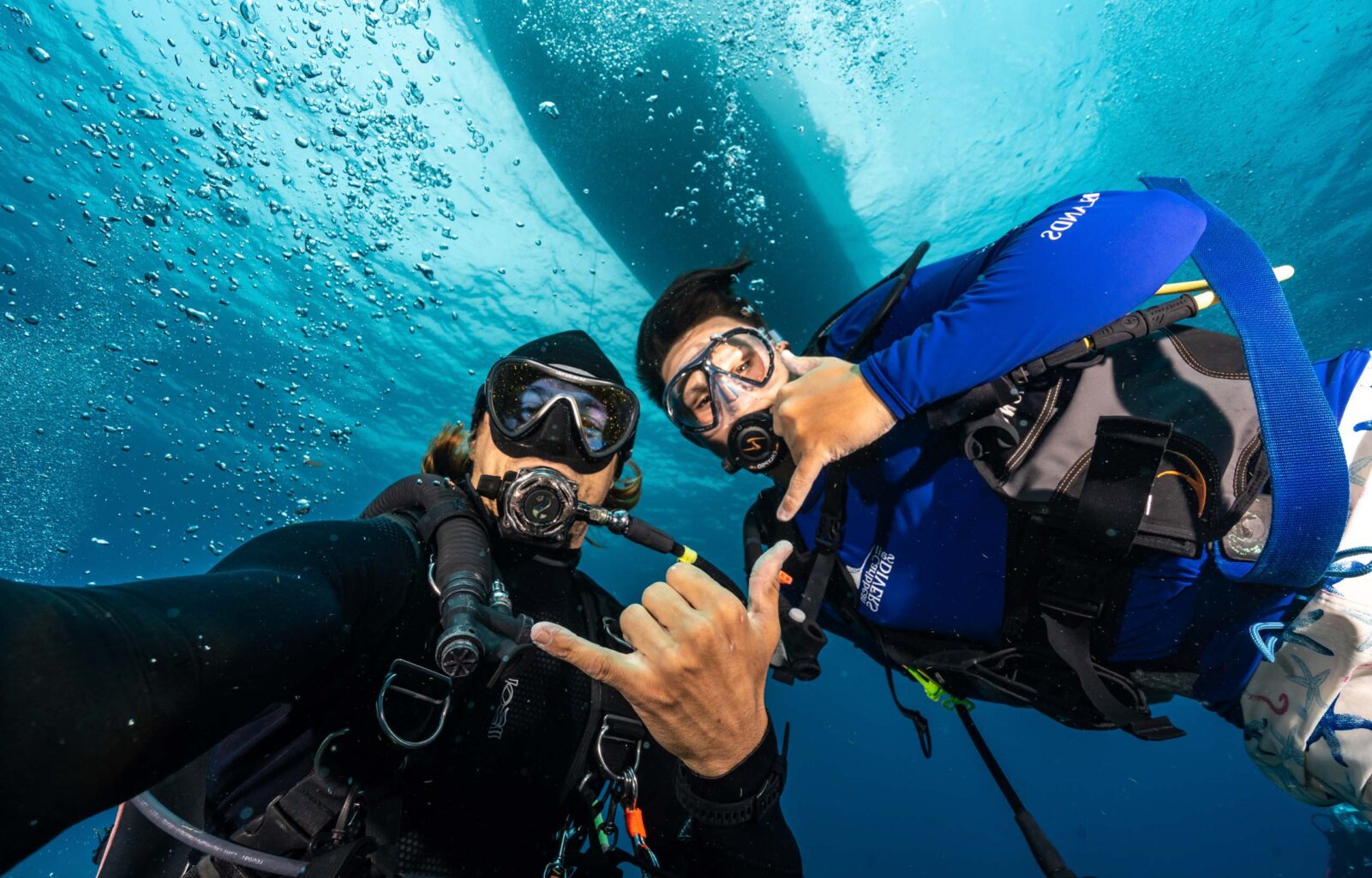 Two scuba divers taking a selfie underwater.