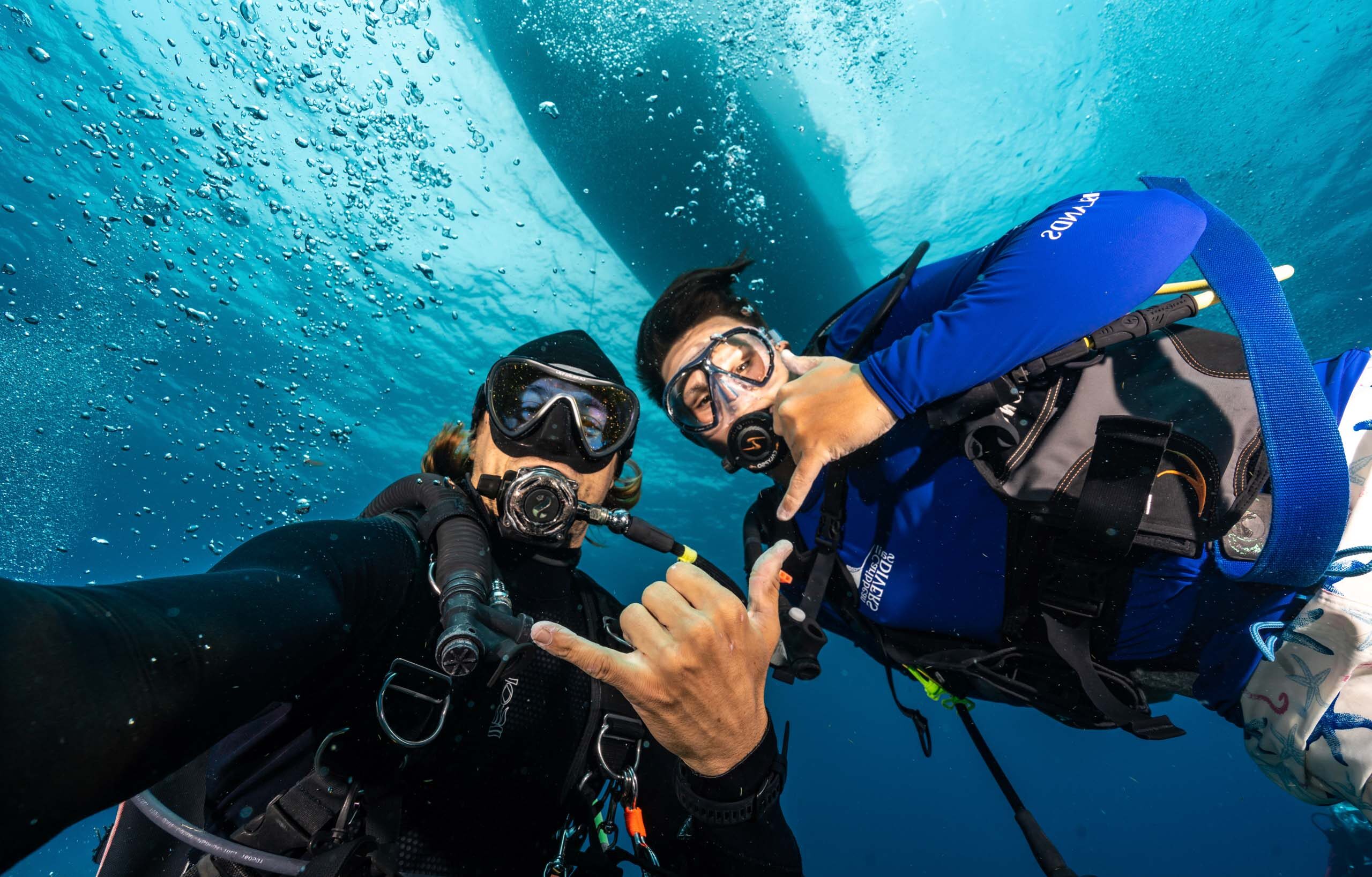 Two scuba divers taking a selfie underwater.