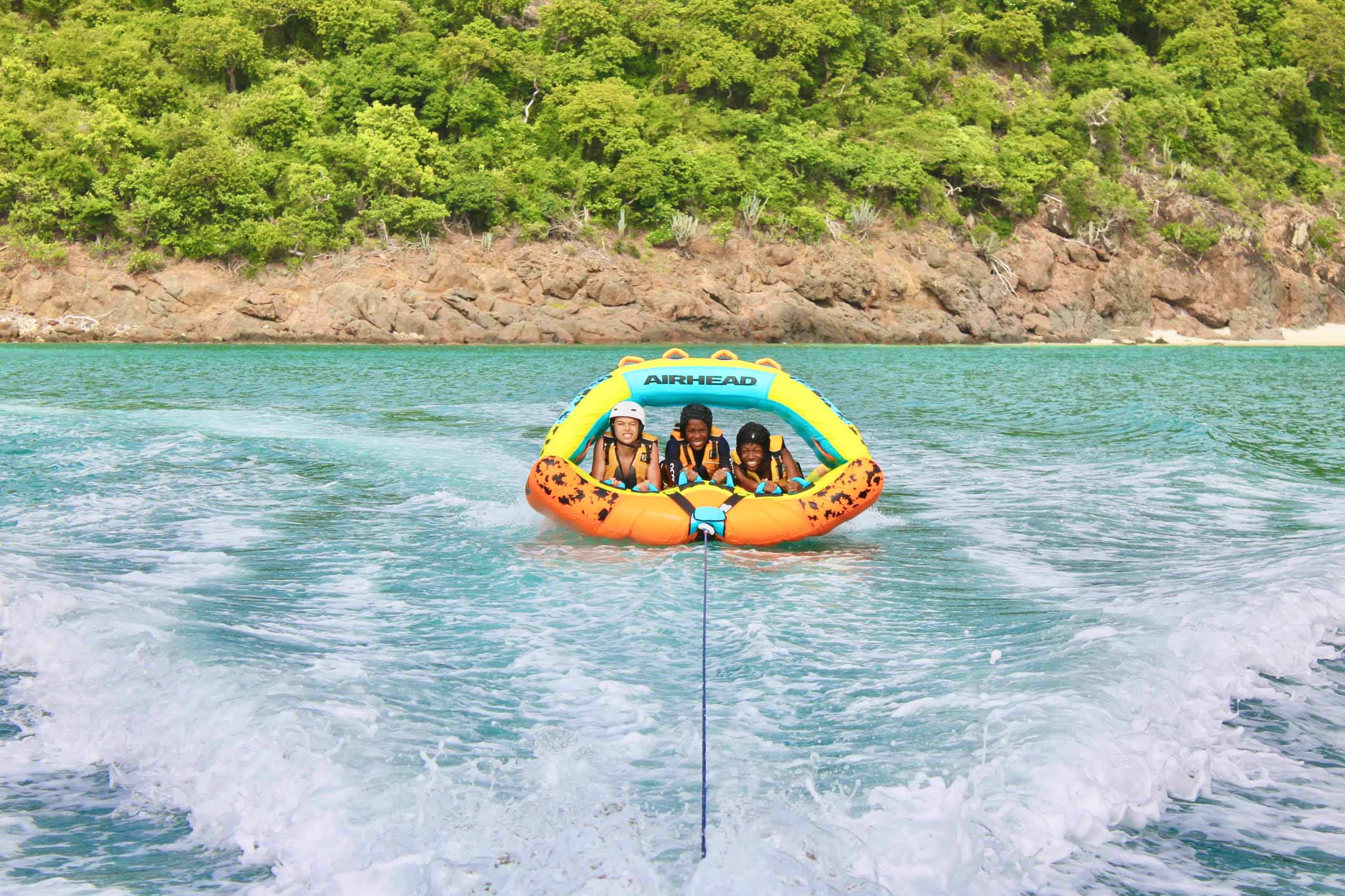 A group of people riding an inflatable boat in the water.